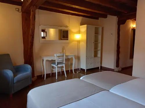 Vista general de habitación con dos camas individuales y decoración cálida