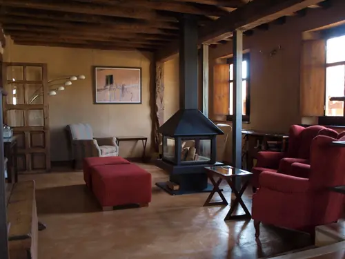 Salón con chimenea, butacas y juegos de mesa